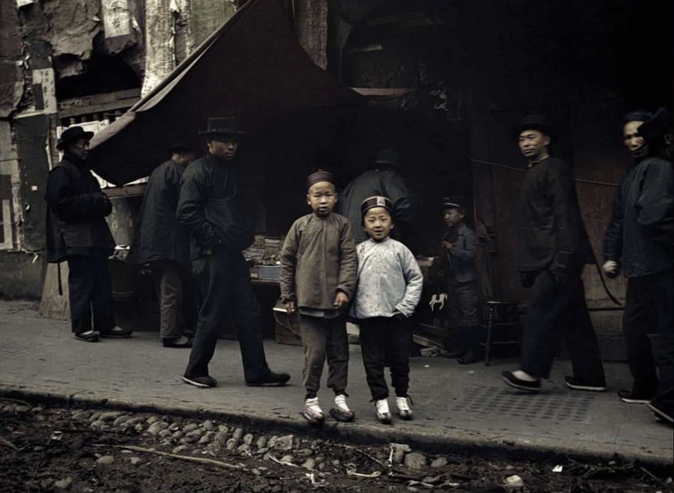 Two children looking towards the camera photographed by Arnold Genthe on a street in Chinatown, San Francisco in c. 1906 